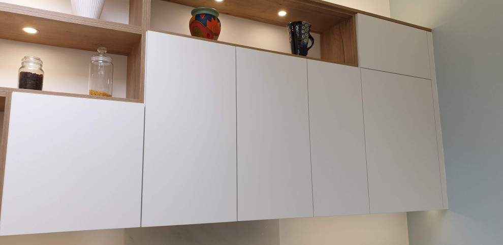 Inspiration for a large modern u-shaped eat-in kitchen in Other with an undermount sink, flat-panel cabinets, white cabinets, onyx benchtops, white splashback, black appliances, linoleum floors, with island, grey floor and white benchtop.