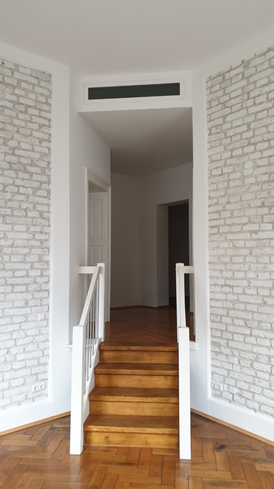 This is an example of a mid-sized scandinavian foyer in Munich with white walls and brick walls.