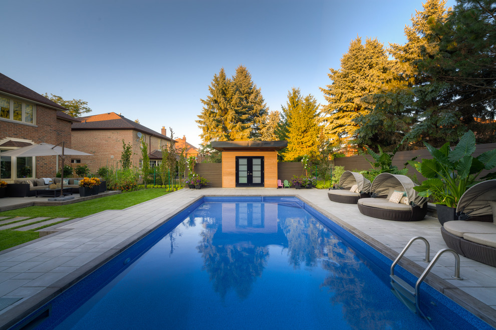 Inspiration for a contemporary backyard rectangular pool in Toronto with a pool house.