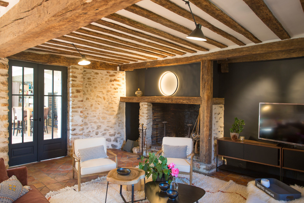 Country enclosed living room in Paris with black walls, a standard fireplace and a stone fireplace surround.