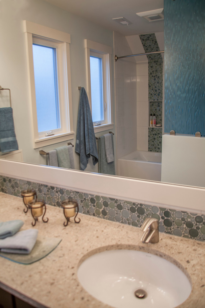 Transitional blue tile and glass sheet porcelain tile tub/shower combo photo in Seattle with an undermount sink, shaker cabinets, dark wood cabinets, quartzite countertops, a one-piece toilet and white walls