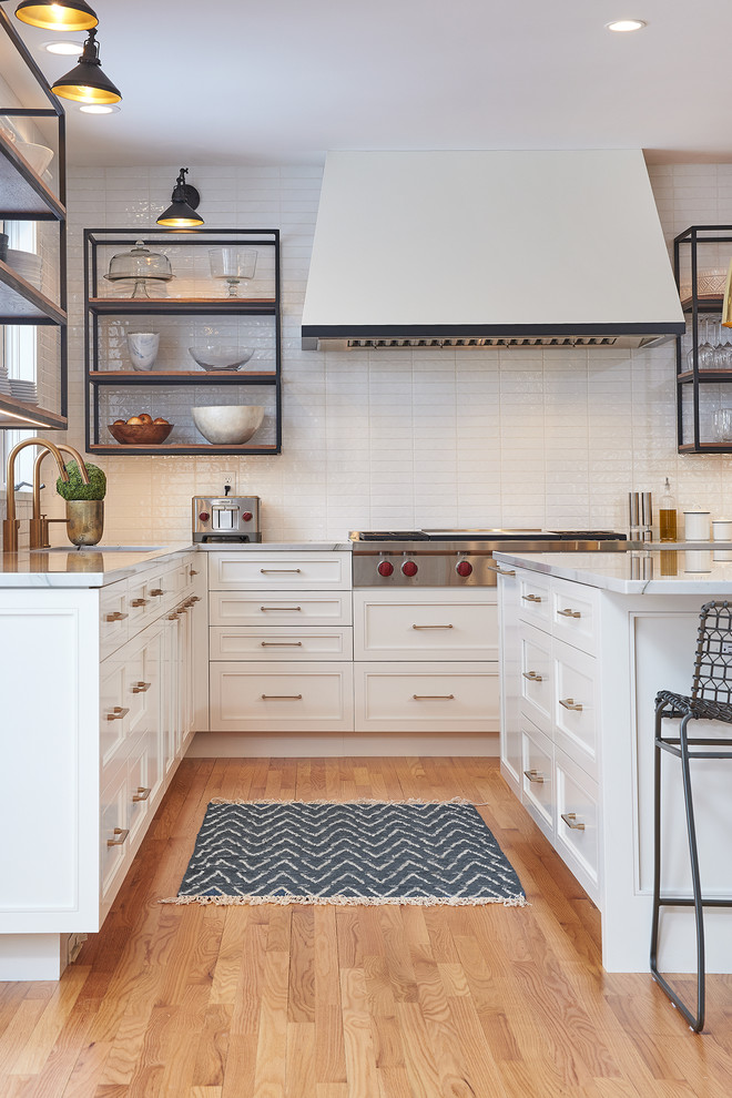 Design ideas for a large transitional l-shaped eat-in kitchen in Minneapolis with an undermount sink, flat-panel cabinets, white cabinets, quartzite benchtops, white splashback, subway tile splashback, stainless steel appliances, light hardwood floors, with island, yellow floor and white benchtop.