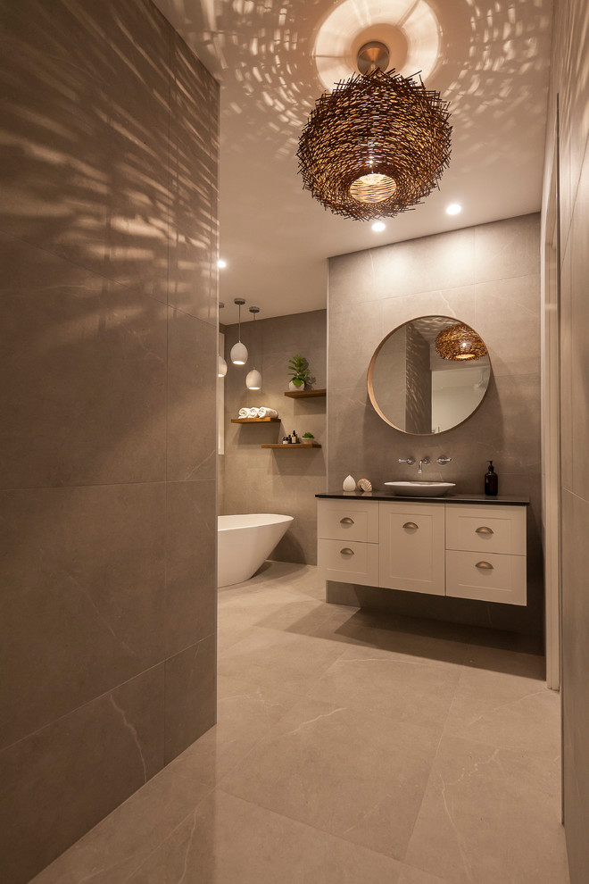 Photo of a large contemporary master bathroom in Sydney with shaker cabinets, white cabinets, a freestanding tub, a double shower, a one-piece toilet, gray tile, porcelain tile, grey walls, porcelain floors, a pedestal sink and engineered quartz benchtops.