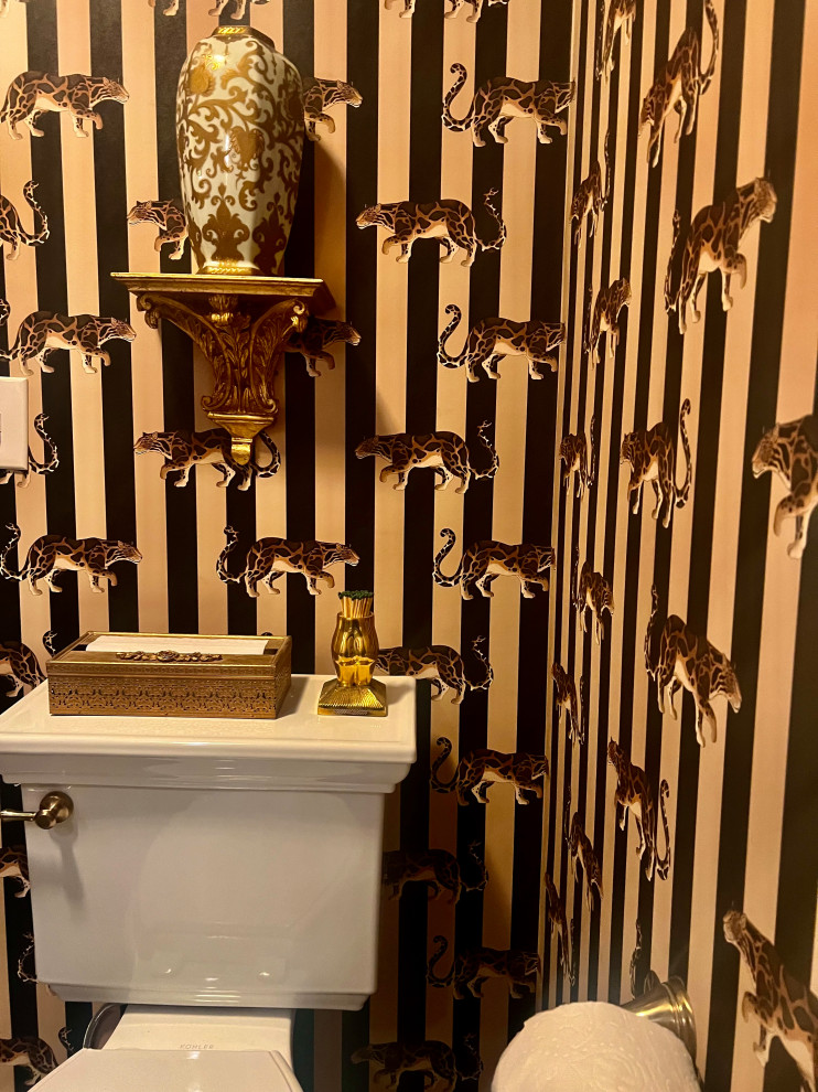 Example of a mid-sized classic ceramic tile, wallpaper and beige floor powder room design in Other with white cabinets, a two-piece toilet, multicolored walls, a freestanding vanity and a pedestal sink
