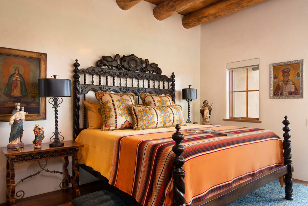 Guest bedroom in Albuquerque with beige walls, medium hardwood floors, no fireplace, brown floor and exposed beam.