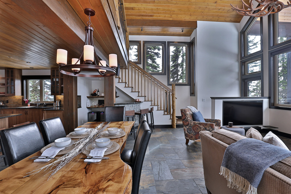 Mountain style slate floor, gray floor and wood ceiling great room photo in Vancouver with white walls, a corner fireplace and a stacked stone fireplace