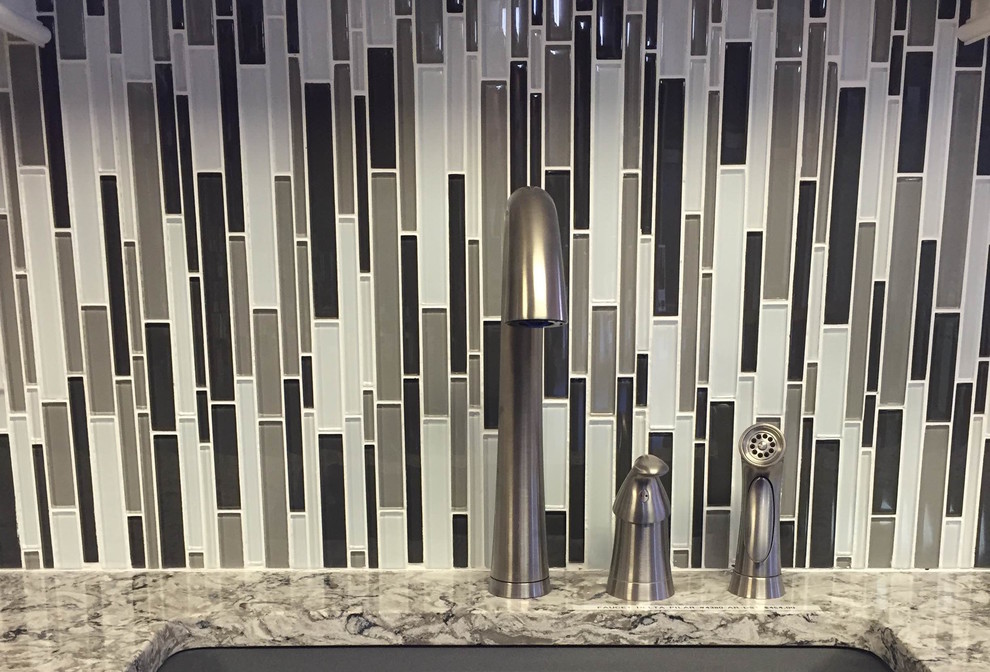 Example of a mid-sized transitional ceramic tile kitchen design in Orange County with an undermount sink, shaker cabinets, white cabinets, granite countertops, multicolored backsplash, matchstick tile backsplash, stainless steel appliances and an island