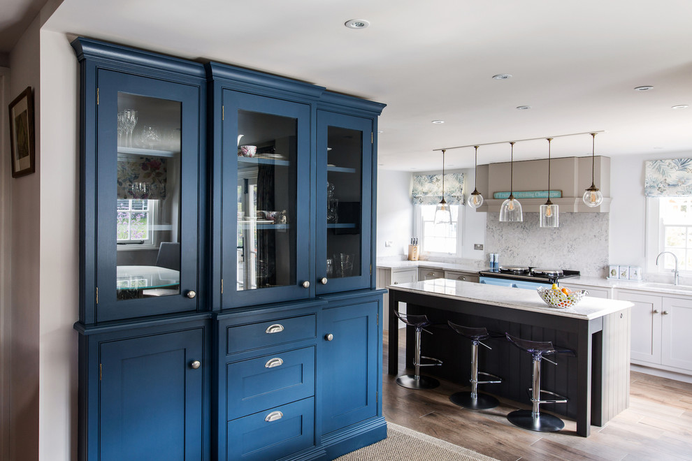 Inspiration for a mid-sized country galley eat-in kitchen in Kent with an integrated sink, shaker cabinets, grey cabinets, quartzite benchtops, grey splashback, marble splashback, coloured appliances, medium hardwood floors, with island and white benchtop.
