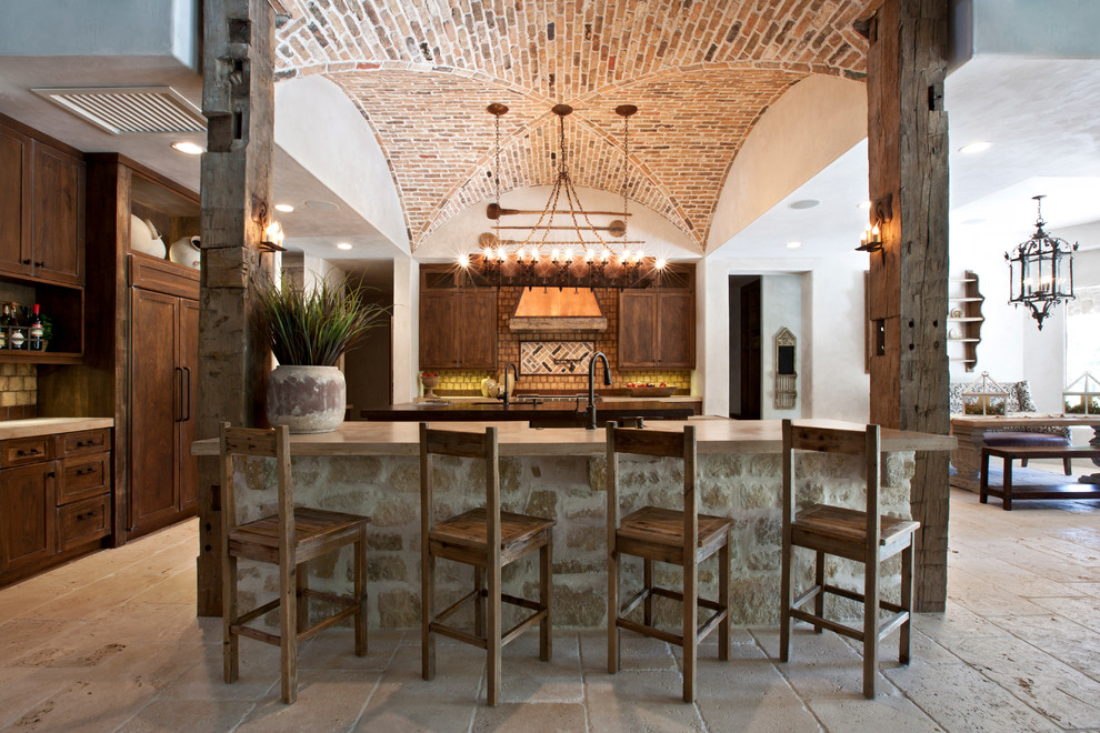 Inspiration for a mediterranean kitchen in Houston with dark wood cabinets, panelled appliances and with island.