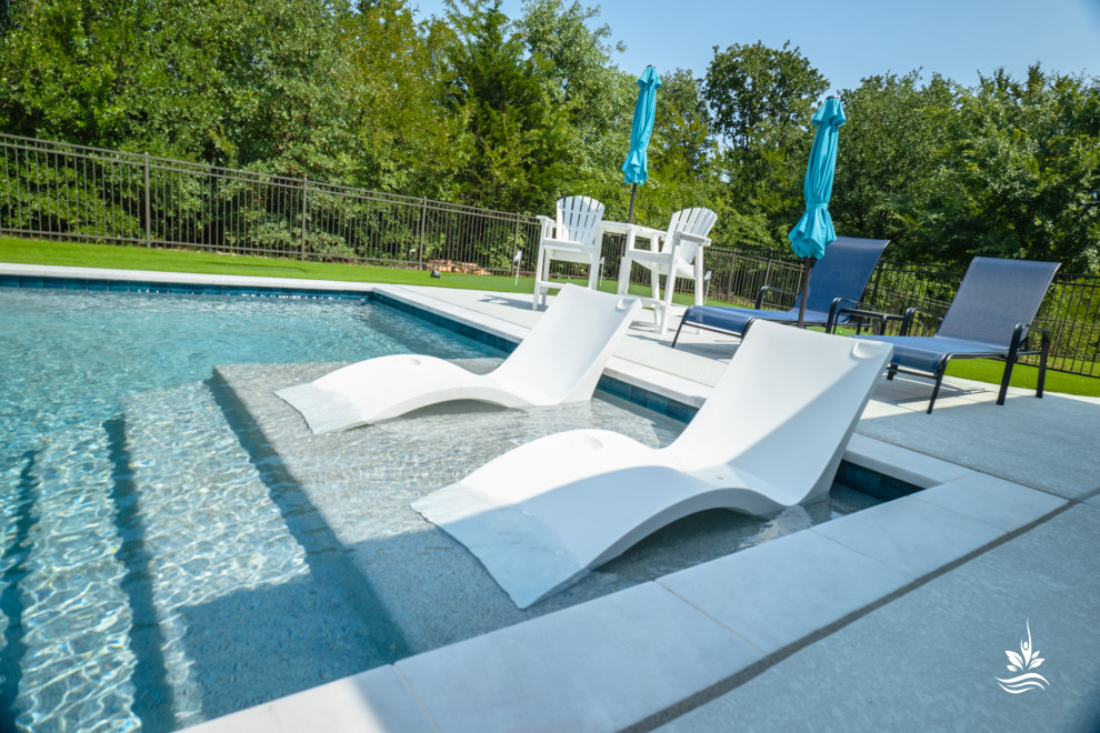 Cette image montre un grand piscine avec aménagement paysager arrière minimaliste rectangle avec une terrasse en bois.