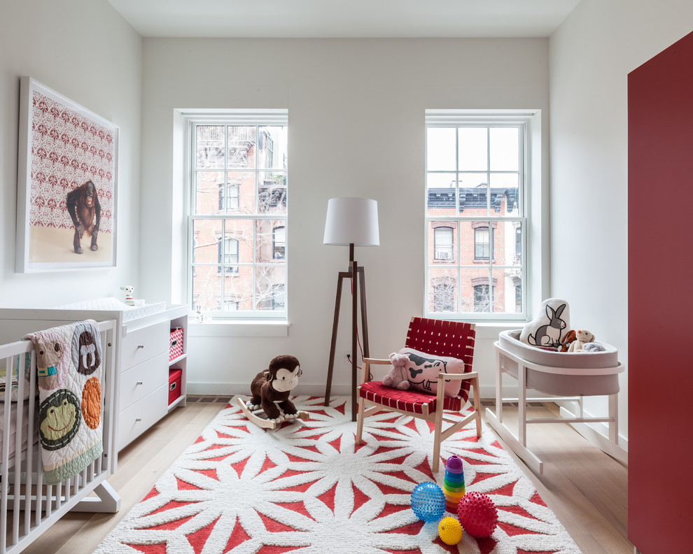 Design ideas for a mid-sized transitional gender-neutral kids' room in New York with white walls and light hardwood floors.
