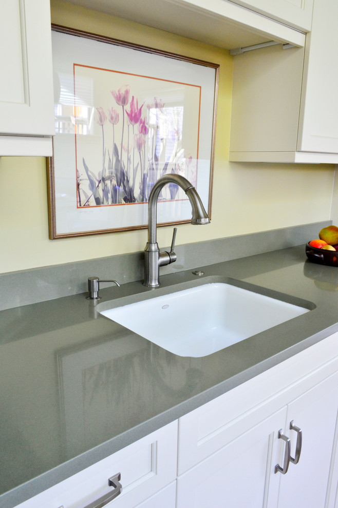 Inspiration for a mid-sized transitional light wood floor enclosed kitchen remodel in Seattle with an undermount sink, recessed-panel cabinets, white cabinets, quartz countertops, green backsplash, stone slab backsplash, stainless steel appliances and a peninsula
