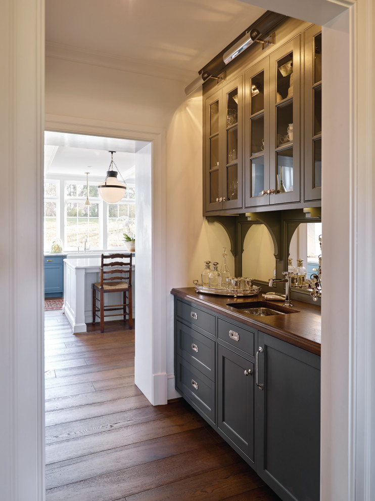 Inspiration for a mid-sized traditional galley kitchen pantry in Other with wood benchtops, panelled appliances, medium hardwood floors, brown floor and brown benchtop.