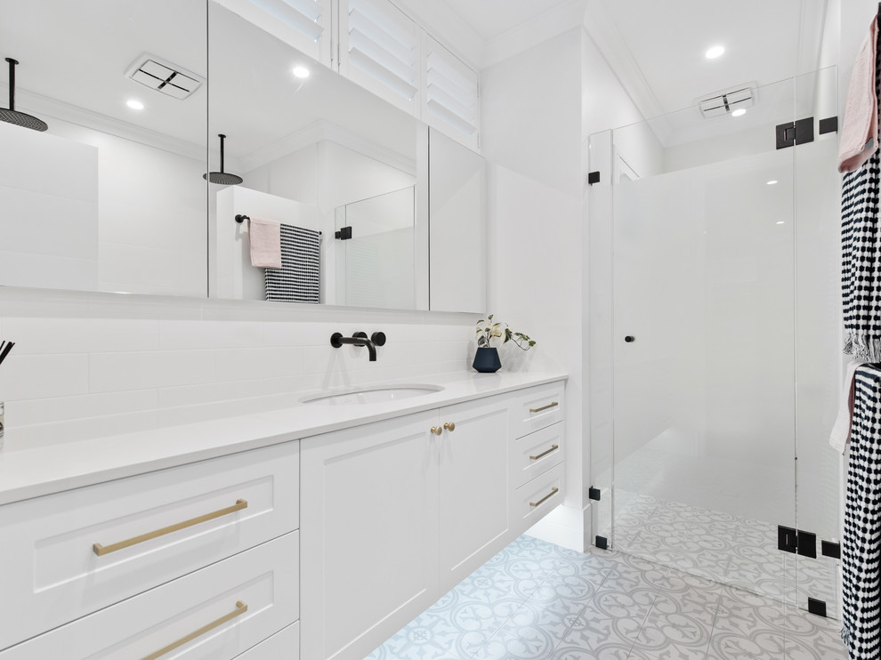 Design ideas for a contemporary 3/4 bathroom in Perth with shaker cabinets, white cabinets, an alcove shower, white tile, white walls, an undermount sink, grey floor, a hinged shower door and white benchtops.