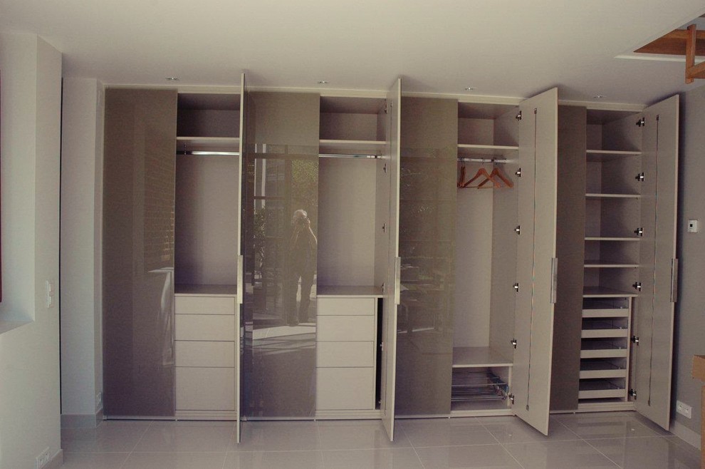 Photo of an expansive contemporary gender-neutral built-in wardrobe in Montpellier with glass-front cabinets, brown cabinets and ceramic floors.