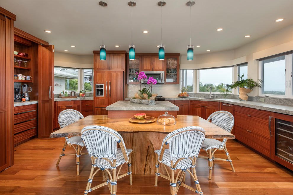 Design ideas for a large tropical u-shaped eat-in kitchen in Hawaii with flat-panel cabinets, with island, brown floor, a drop-in sink, dark wood cabinets, granite benchtops, white splashback, glass tile splashback, stainless steel appliances and dark hardwood floors.