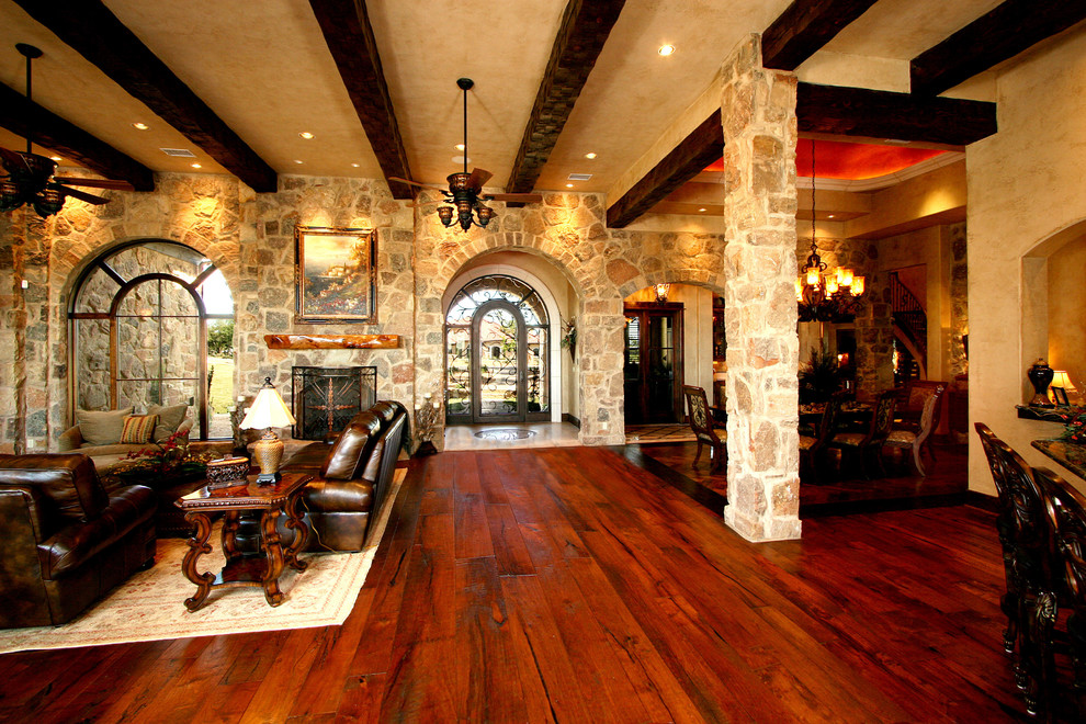 Inspiration for an expansive mediterranean open concept living room in Austin with a stone fireplace surround.