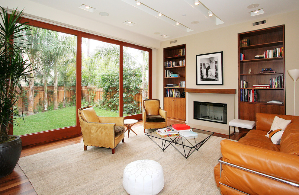 Design ideas for a midcentury living room in Los Angeles with a library and a standard fireplace.