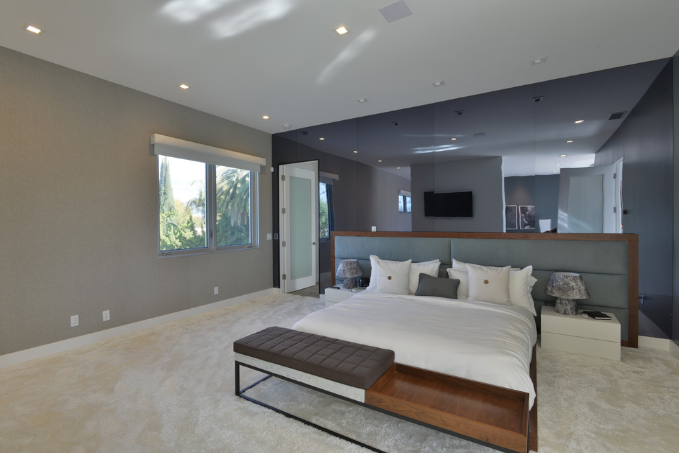 Large modern master bedroom in Los Angeles with grey walls and carpet.