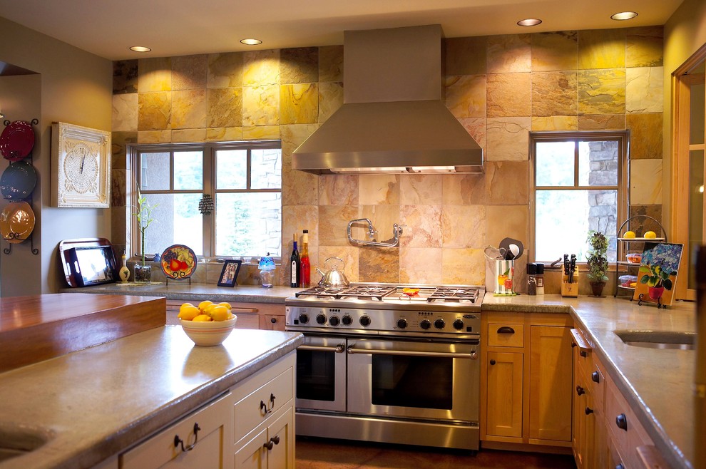 Photo of an eclectic kitchen in Seattle with stainless steel appliances, concrete benchtops, brown splashback, medium wood cabinets, with island and slate splashback.