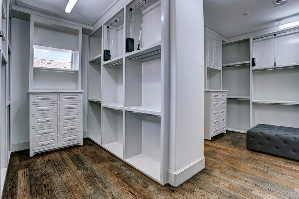 This is an example of a mid-sized contemporary dressing room in Houston with raised-panel cabinets, distressed cabinets, dark hardwood floors and brown floor.