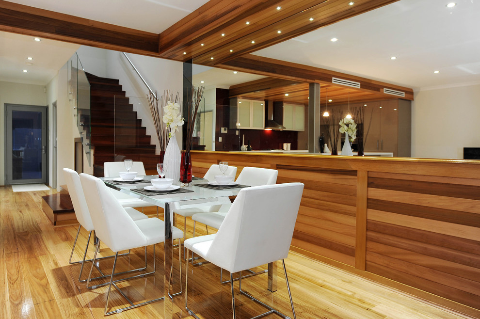 This is an example of a mid-sized contemporary open plan dining in Perth with white walls and light hardwood floors.