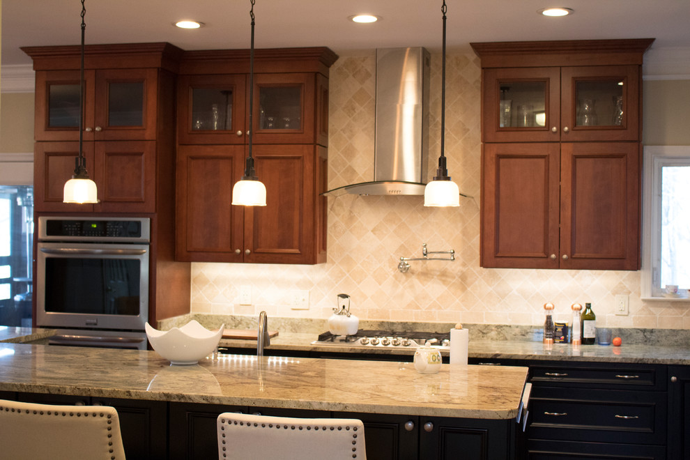 Large transitional l-shaped dark wood floor and brown floor enclosed kitchen photo in DC Metro with a double-bowl sink, raised-panel cabinets, dark wood cabinets, granite countertops, beige backsplash, limestone backsplash, stainless steel appliances and an island