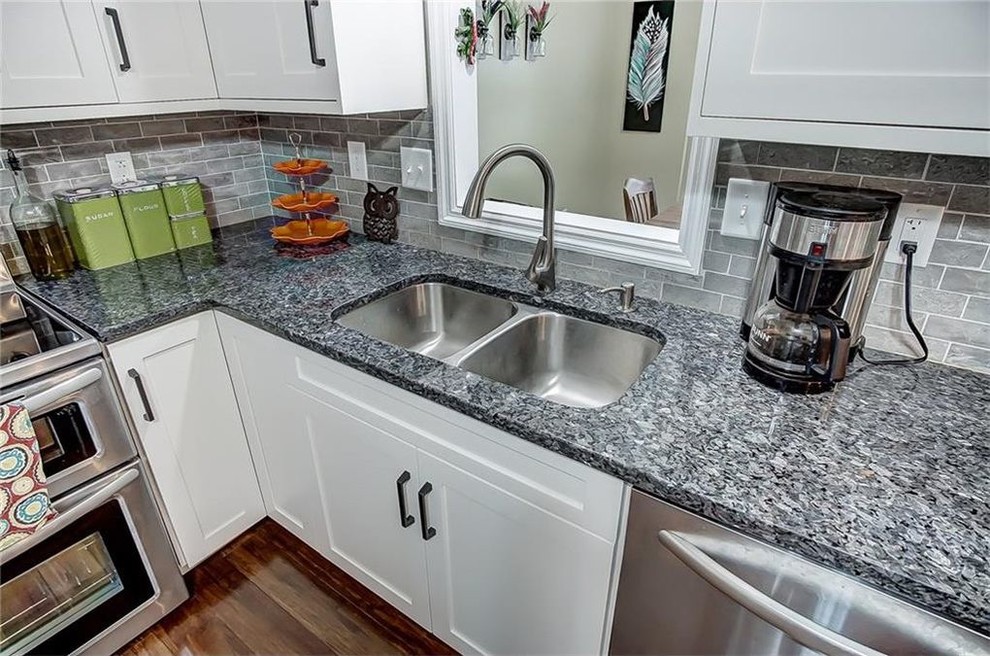 Inspiration for a transitional medium tone wood floor kitchen remodel with shaker cabinets, white cabinets and granite countertops