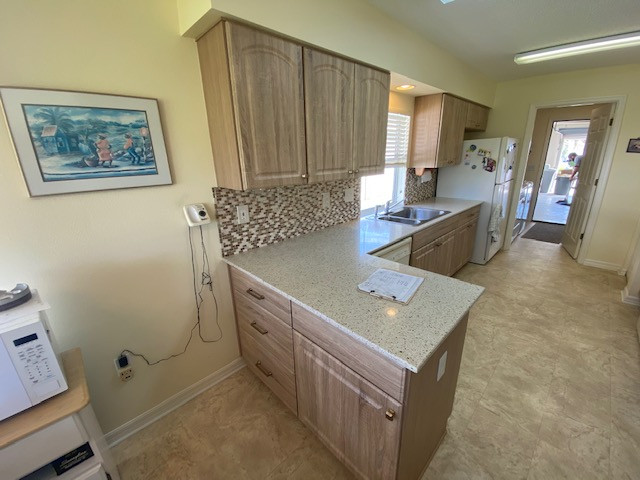 Inspiration for a mid-sized enclosed kitchen remodel with raised-panel cabinets, light wood cabinets and a peninsula