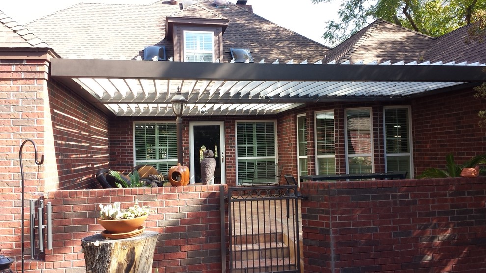 Inspiration for a mid-sized traditional front yard patio in Dallas with tile and a pergola.