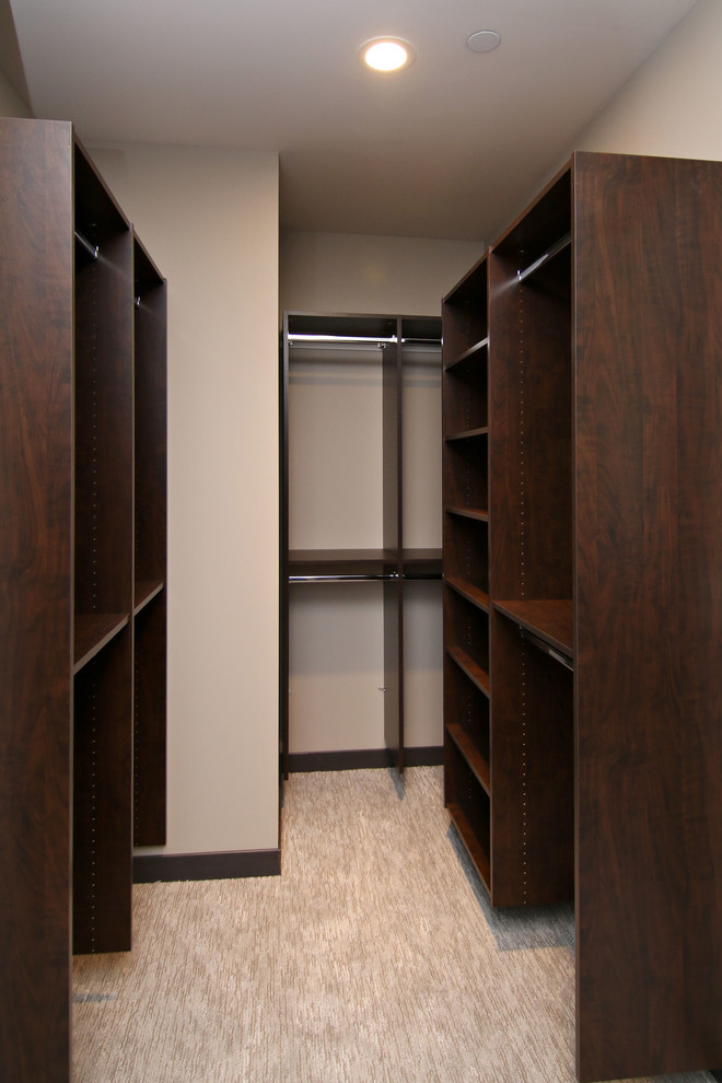 Design ideas for a mid-sized industrial walk-in wardrobe in Minneapolis with open cabinets, dark wood cabinets and carpet.