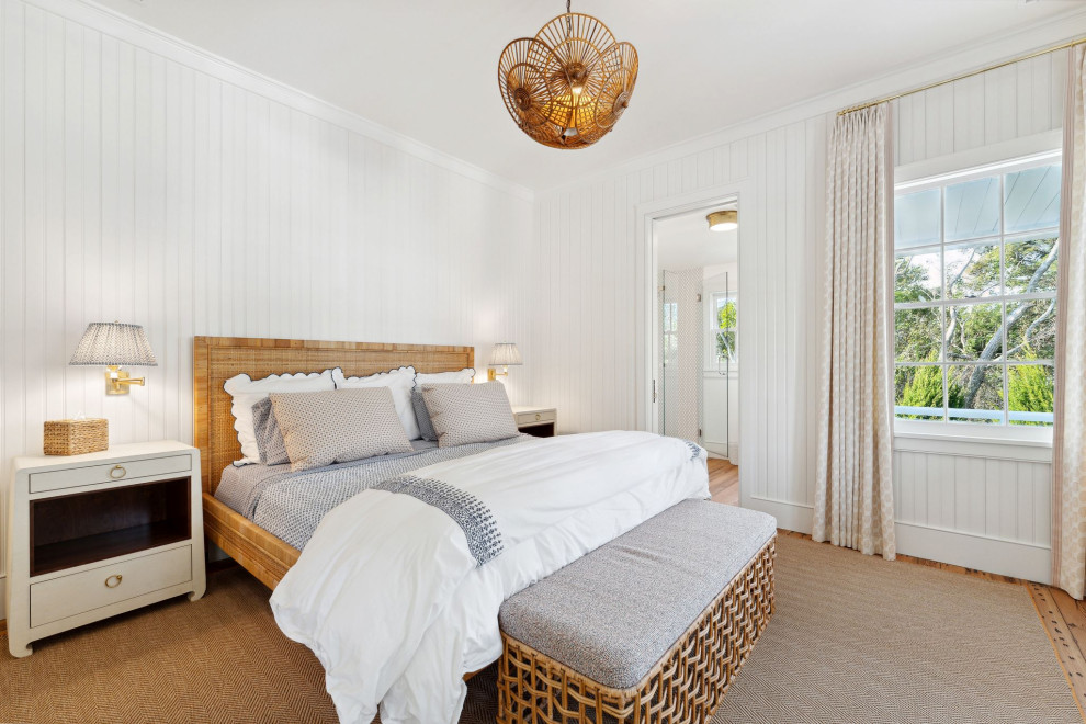 Historic Sea Cabins - Warm and inviting guest bedroom featuring original heart pine floors, vertical beadboard paneling on the walls, and custom rugs and furniture.