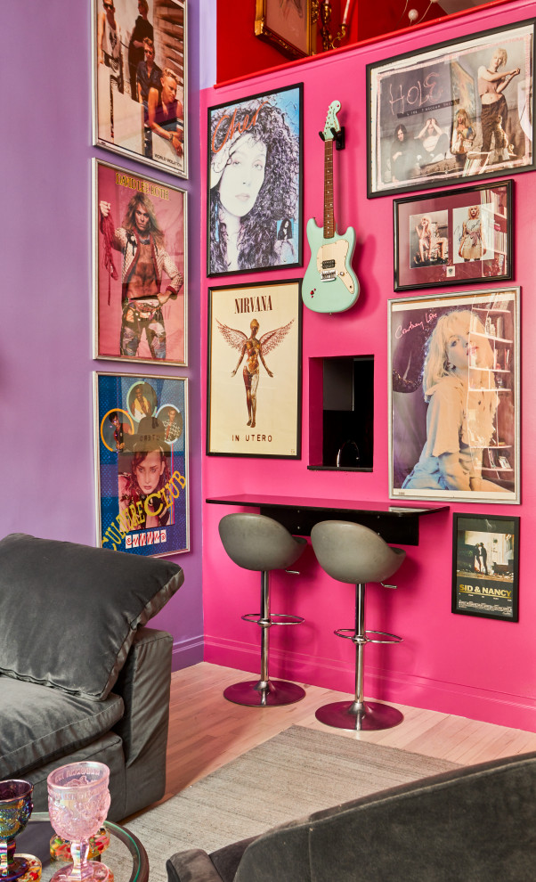 Modelo de salón tipo loft bohemio de tamaño medio con paredes rosas, suelo de madera clara, televisor colgado en la pared y suelo beige