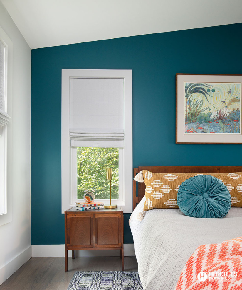 Modelo de dormitorio principal y abovedado retro de tamaño medio con paredes azules, suelo de madera en tonos medios y suelo gris