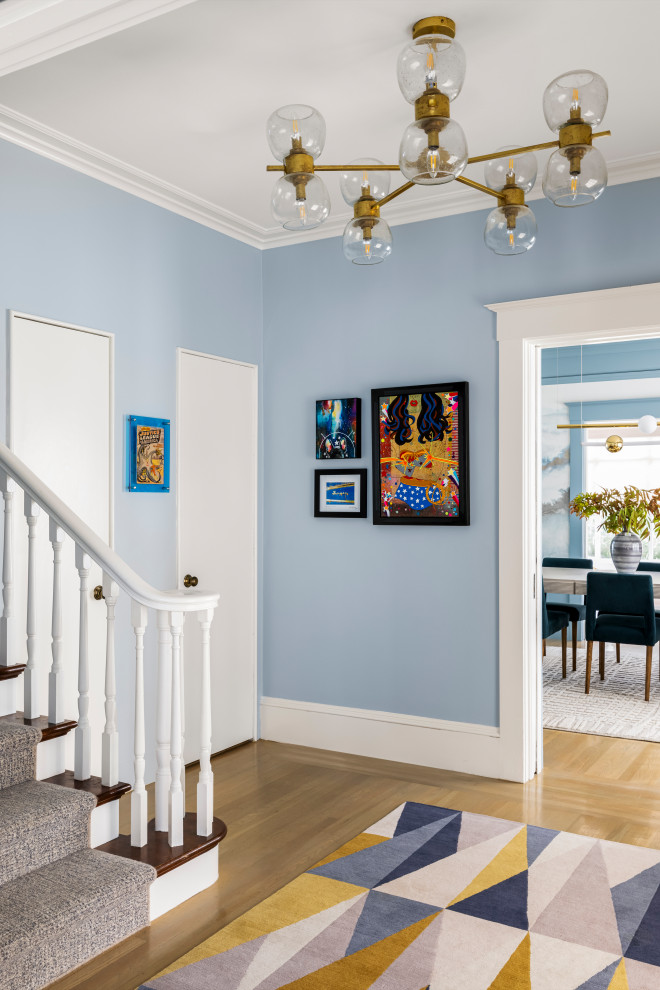 Photo of a mid-sized transitional entryway in San Francisco with blue walls, light hardwood floors, a single front door, a white front door and beige floor.