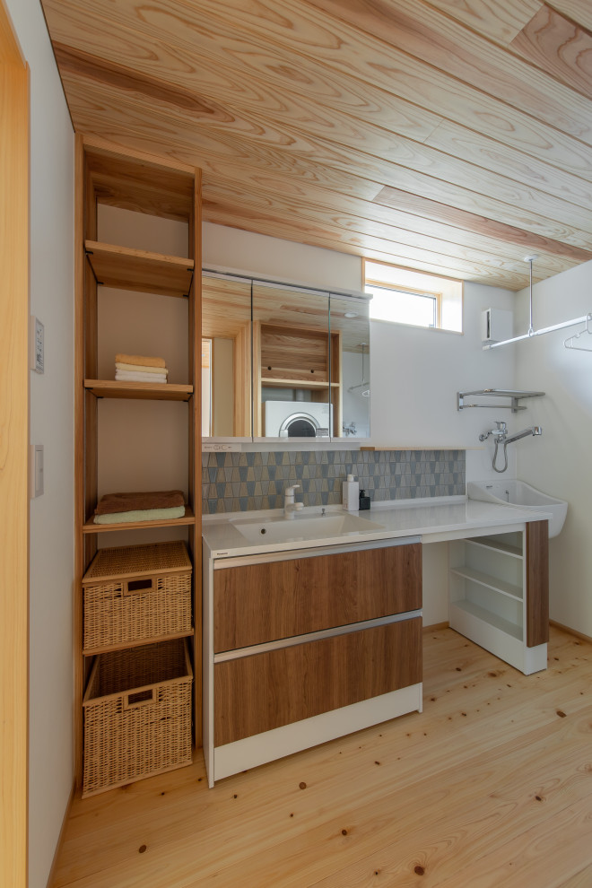 Immagine di un bagno di servizio con piastrelle blu, pavimento in legno massello medio, soffitto in legno e carta da parati