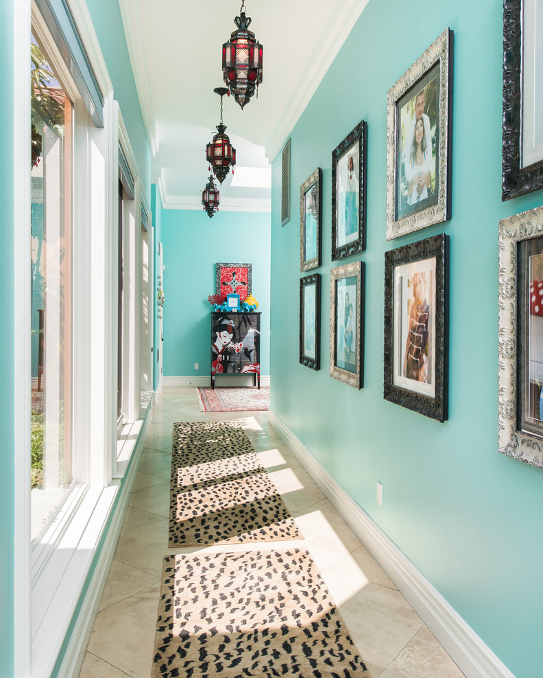 Eclectic hallway in Los Angeles with blue walls and beige floor.