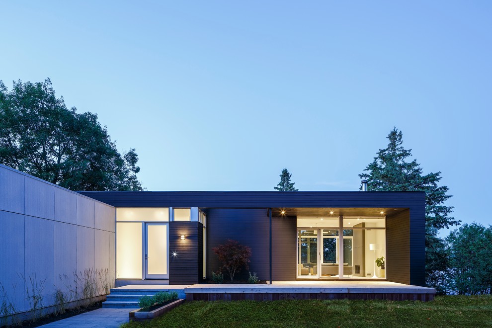 Inspiration for a large contemporary two-storey black exterior in Ottawa with mixed siding and a flat roof.