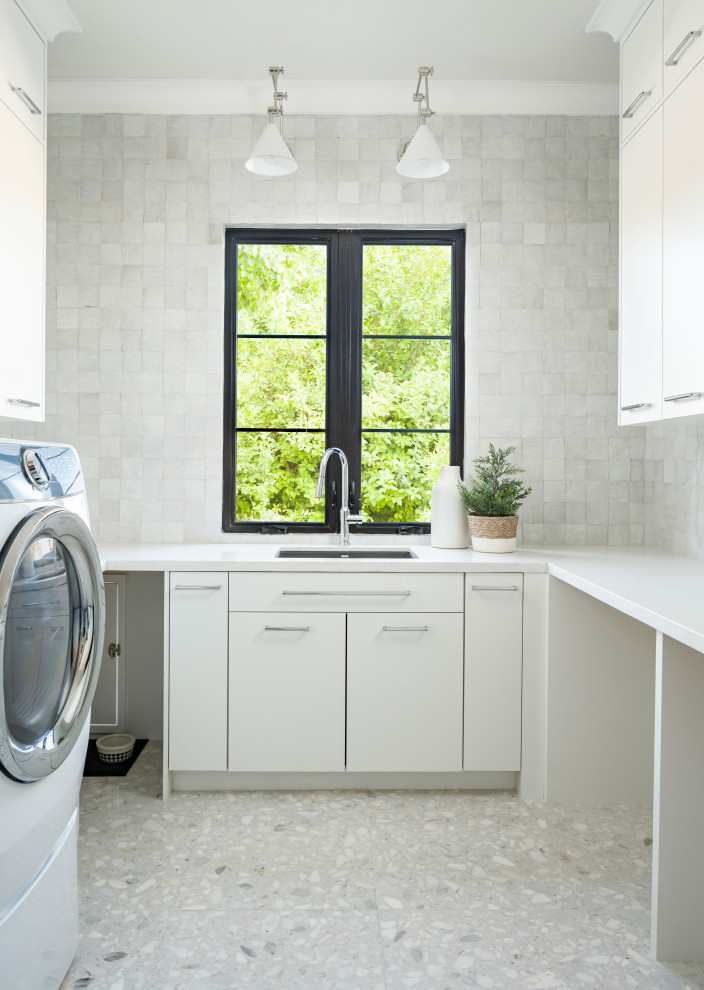 This is an example of a large transitional u-shaped dedicated laundry room in Phoenix with an undermount sink, flat-panel cabinets, white cabinets, quartz benchtops, white splashback, terra-cotta splashback, white walls, marble floors, a side-by-side washer and dryer, white floor and white benchtop.