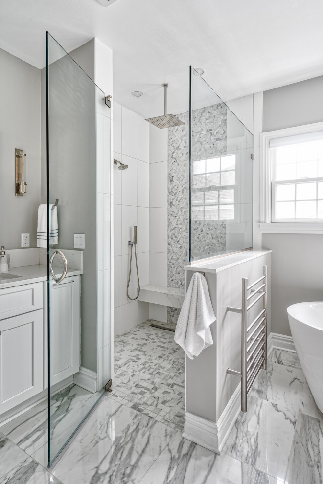 Expansive transitional master bathroom in New York with shaker cabinets, white cabinets, a freestanding tub, a curbless shower, a bidet, white tile, porcelain tile, beige walls, marble floors, an undermount sink, quartzite benchtops, a hinged shower door and white benchtops.
