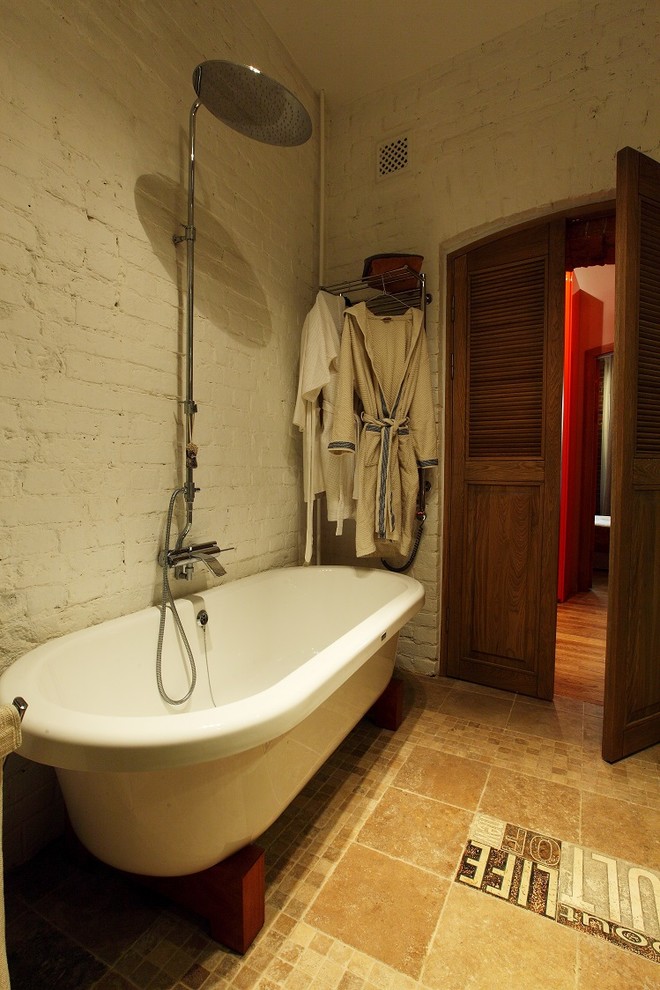Inspiration for an industrial bathroom in Moscow with a claw-foot tub and white walls.
