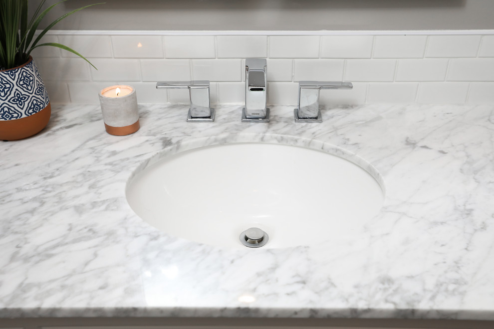 Inspiration for a mid-sized transitional white tile gray floor alcove bathtub remodel with shaker cabinets, white cabinets, a one-piece toilet, gray walls, an undermount sink and gray countertops