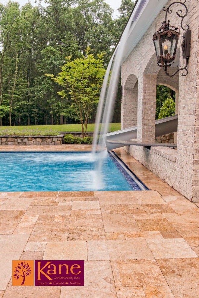 Photo of a large contemporary backyard rectangular pool in DC Metro with a water slide and natural stone pavers.