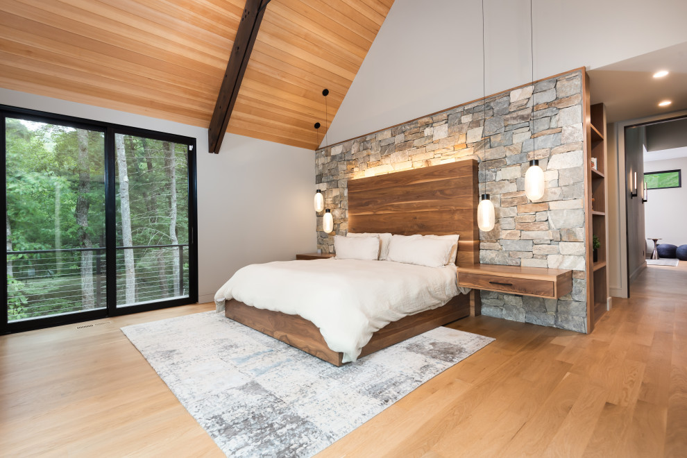 Skandinavisches Hauptschlafzimmer mit hellem Holzboden und gewölbter Decke in Sonstige