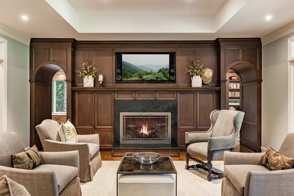 Design ideas for a traditional formal living room in Other with medium hardwood floors, a standard fireplace, a stone fireplace surround, a built-in media wall and grey walls.