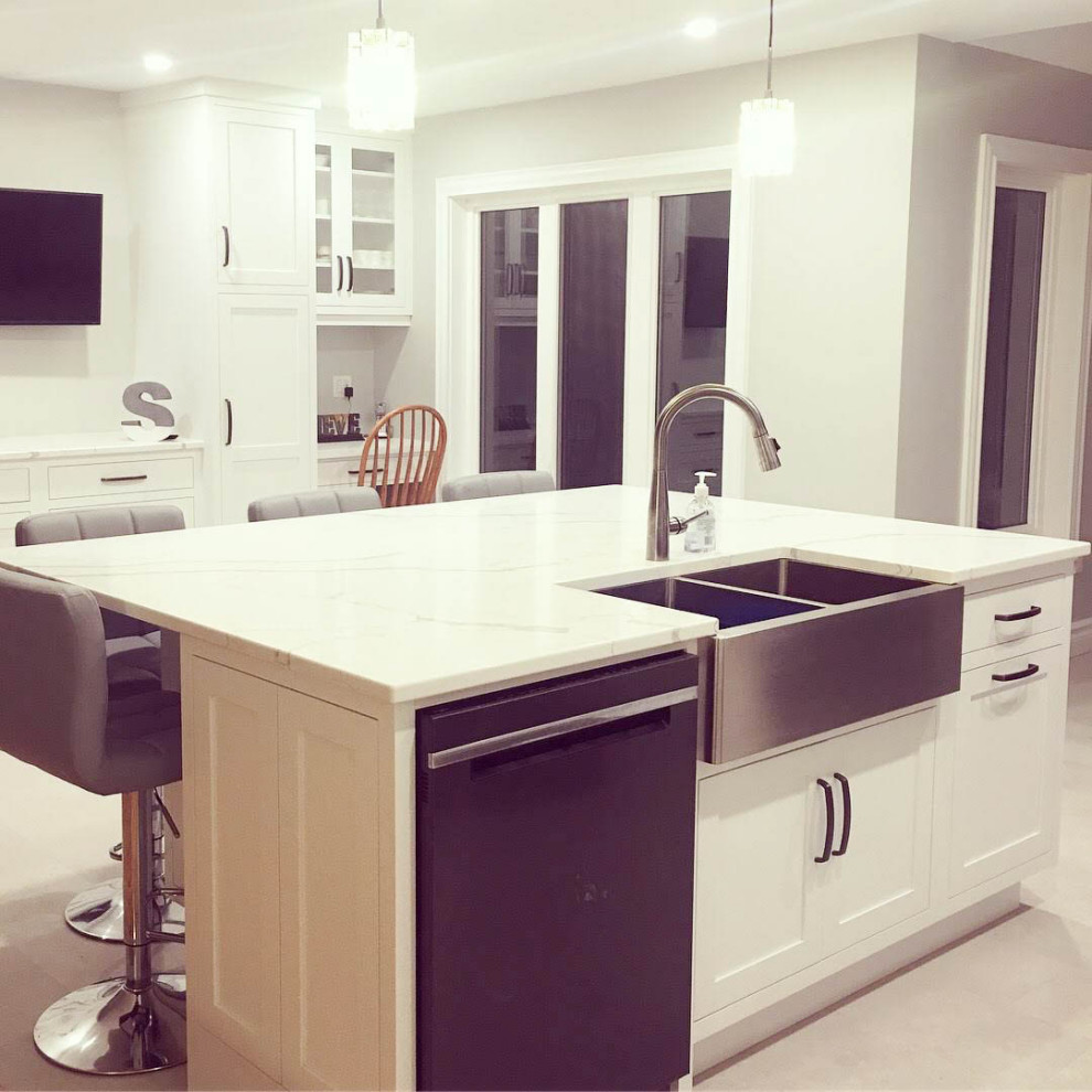 Inspiration for a mid-sized transitional u-shaped porcelain tile and white floor eat-in kitchen remodel with a farmhouse sink, shaker cabinets, white cabinets, quartzite countertops, white backsplash, subway tile backsplash, stainless steel appliances, an island and white countertops