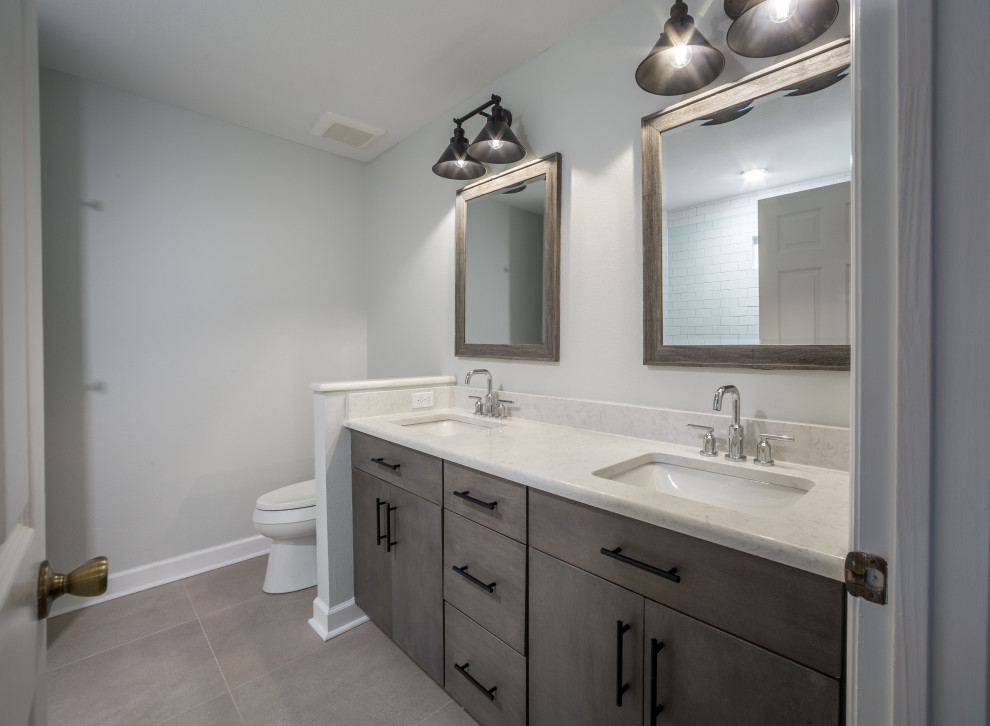 Mid-sized traditional master bathroom with flat-panel cabinets, brown cabinets, a curbless shower, a one-piece toilet, white tile, porcelain tile, grey walls, porcelain floors, an undermount sink, quartzite benchtops, brown floor, an open shower, white benchtops, a niche, a double vanity and a built-in vanity.