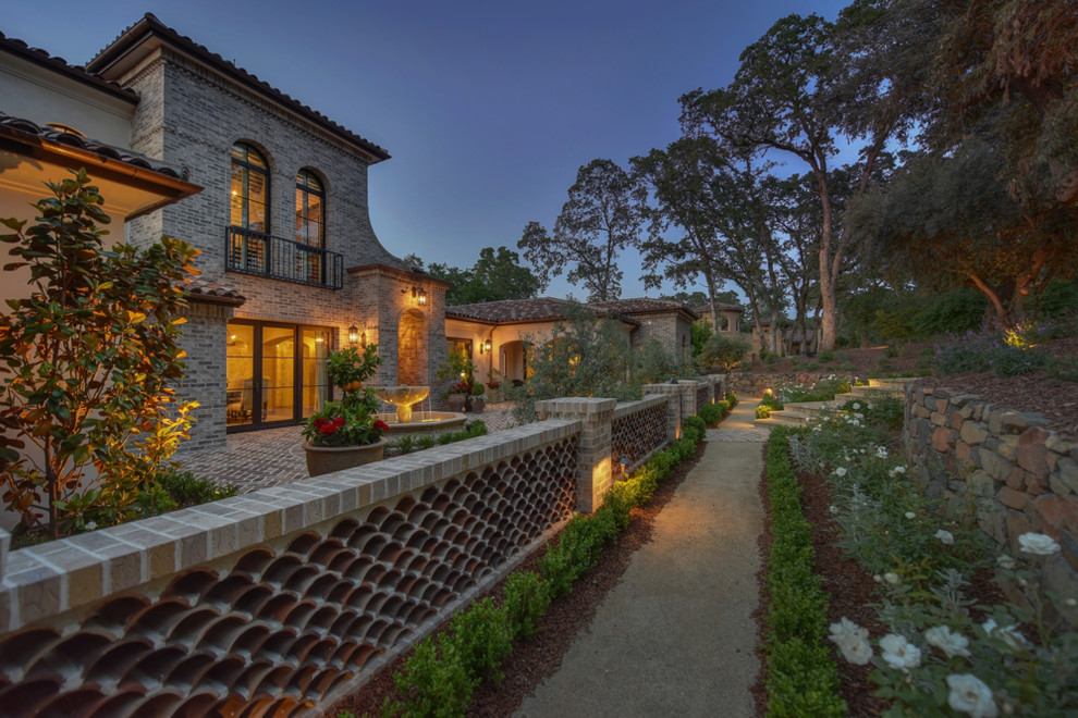 Inspiration for an expansive mediterranean two-storey stucco beige house exterior in Sacramento with a tile roof.
