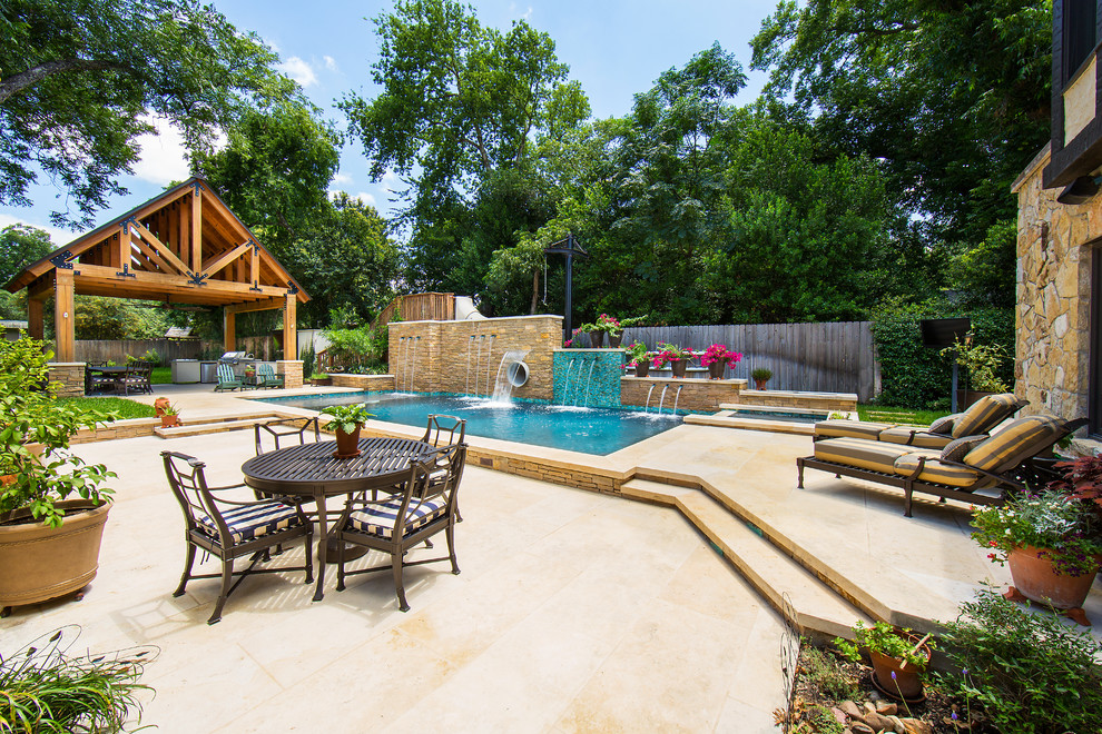 Large country side yard rectangular lap pool in Austin with a water slide and natural stone pavers.