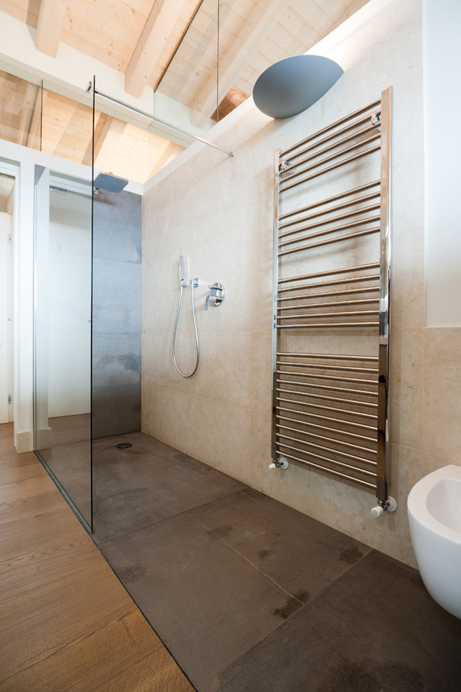 This is an example of a mid-sized modern 3/4 bathroom in Other with black cabinets, a curbless shower, a two-piece toilet, limestone, beige walls, dark hardwood floors, an undermount sink, marble benchtops, brown floor, a sliding shower screen and beige tile.